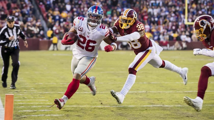 LANDOVER, MD - DECEMBER 22: Saquon Barkley #26 of the New York Giants is shoved out of bounds by Kayvon Webster #38 of the Washington Redskins during overtime at FedExField on December 22, 2019 in Landover, Maryland.