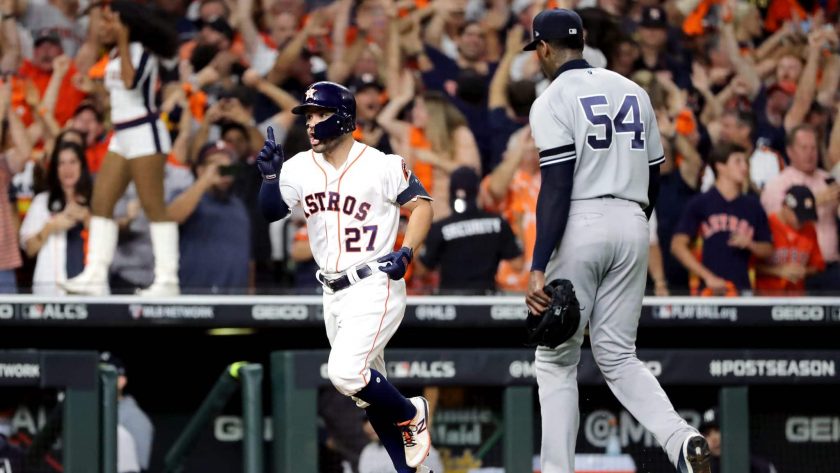 HOUSTON, TEXAS - OCTOBER 19: Jose Altuve #27 of the Houston Astros comes home to score following his ninth inning walk-off two-run home run as Aroldis Chapman #54 of the New York Yankees walks off the field in game six of the American League Championship Series at Minute Maid Park on October 19, 2019 in Houston, Texas. The Astros defeated the Yankees 6-4.