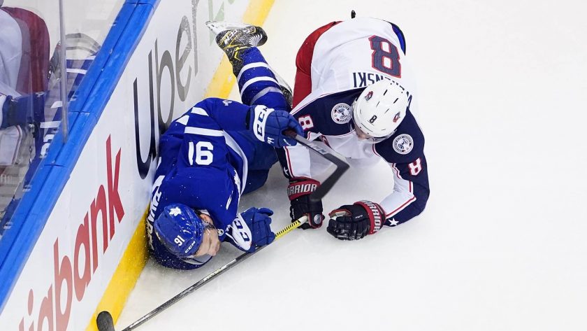 TORONTO, ONTARIO - AUGUST 09: Zach Werenski #8 of the Columbus Blue Jackets checks John Tavares #91 of the Toronto Maple Leafs into the b in Game Five of the Eastern Conference Qualification Round prior to the 2020 NHL Stanley Cup Playoffs at Scotiabank Arena on August 09, 2020 in Toronto, Ontario.