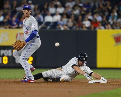 Sep 7, 2016; Bronx, NY, USA; Toronto Blue Jays shortstop Troy Tulowitzki (2) watches the ball as New York Yankees left fielder Brett Gardner (11) is safe at second base after a throwing error in the first inning at Yankee Stadium. Mandatory Credit: Noah K. Murray-USA TODAY Sports