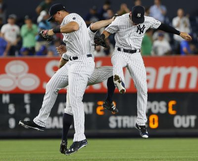 Sep 7, 2016; Bronx, NY, USA; New York Yankees left fielder Brett Gardner (11) , center fielder Jacoby Ellsbury (22) and first baseman Tyler Austin (26) celebrate after defeating the Toronto Blue Jays 2-0 at Yankee Stadium. Mandatory Credit: Noah K. Murray-USA TODAY Sports