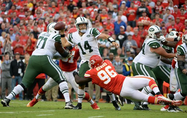 Sep 25, 2016; Kansas City, MO, USA; New York Jets quarterback Ryan Fitzpatrick (14) throws an interception under pressure from Kansas City Chiefs defensive end Jaye Howard (96) in the second half at Arrowhead Stadium. Kansas City won 24-3. Mandatory Credit: John Rieger-USA TODAY Sports