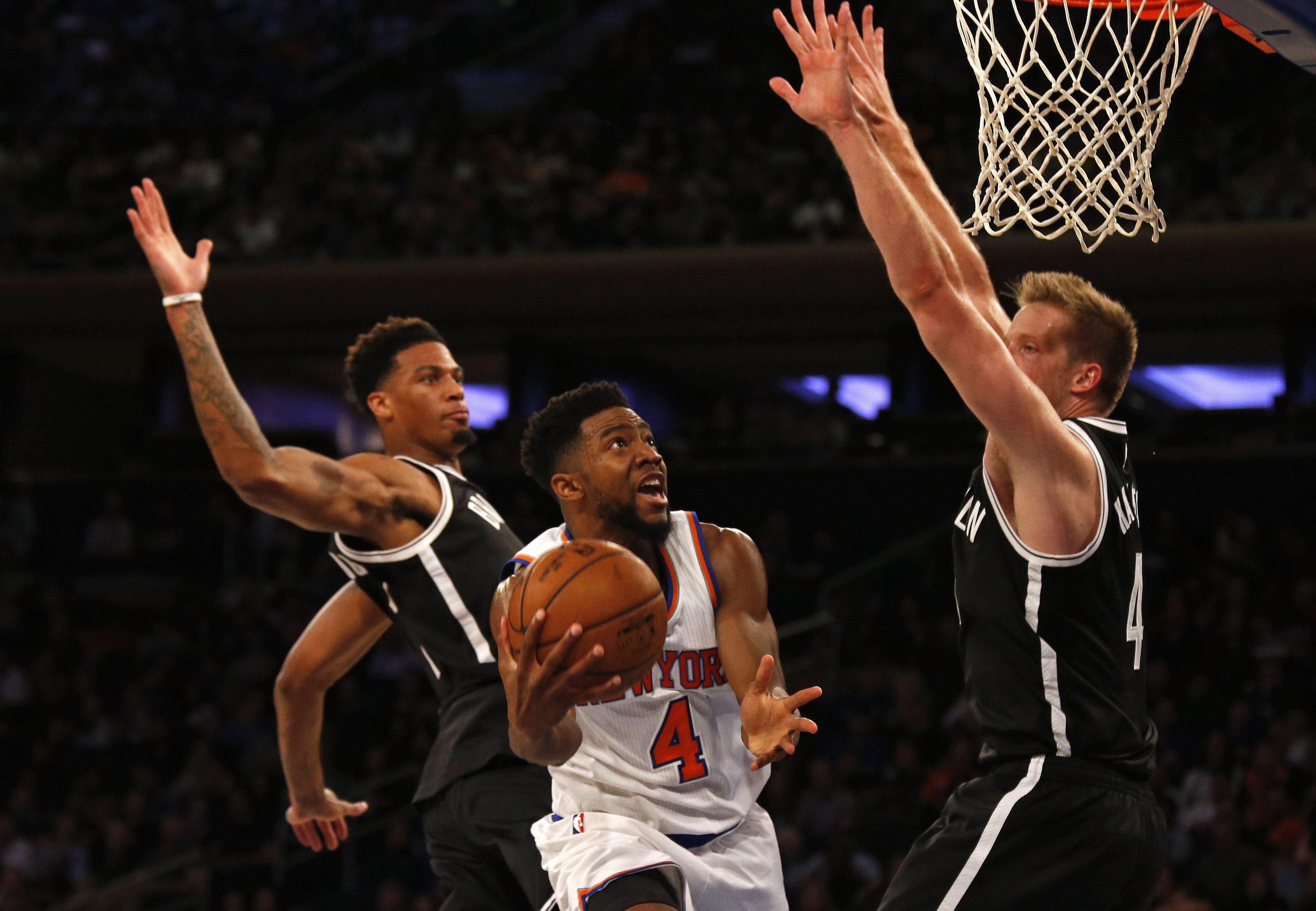 Oct 8, 2016; New York, NY, USA; New York Knicks guard Chasson Randle (4) drives to the net between Brooklyn Nets forward Chris McCullough (1) and Brooklyn Nets forward Justin Hamilton (41) during the first half at Madison Square Garden. Mandatory Credit: Adam Hunger-USA TODAY Sports