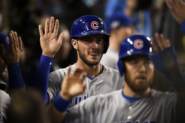 Oct 20, 2016; Los Angeles, CA, USA; Chicago Cubs third baseman Kris Bryant (17) celebrates in the dugout with teammates after scoring a run against the Los Angeles Dodgers in the eighth inning of game five of the 2016 NLCS playoff baseball series against the Los Angeles Dodgers at Dodger Stadium. Mandatory Credit: Kelvin Kuo-USA TODAY Sports