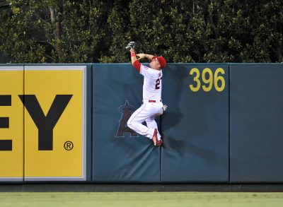 September 26, 2015; Anaheim, CA, USA; Los Angeles Angels center fielder Mike Trout (27) climbs the fence in the fourth inning to catch a fly ball hit by Seattle Mariners first baseman Jesus Montero (not pictured) at Angel Stadium of Anaheim. Mandatory Credit: Gary A. Vasquez-USA TODAY Sports