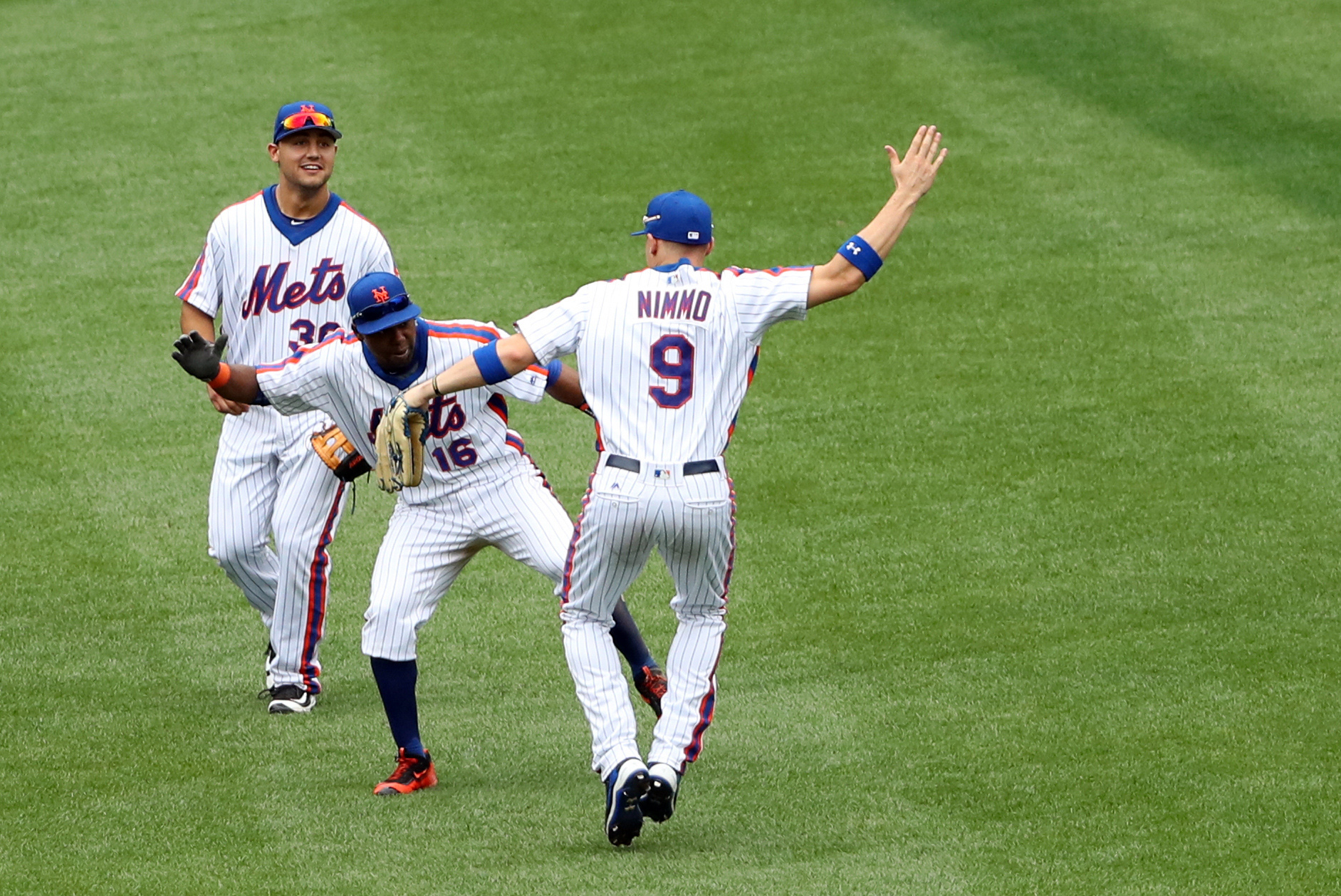 Jul 31, 2016; New York City, NY, USA; New York Mets left fielder Alejandro De Aza (16), left fielder Michael Conforto (30), and right fielder Brandon Nimmo (9) celebrate the win against the Colorado Rockies at Citi Field. New York Mets won 6-4. Mandatory Credit: Anthony Gruppuso-USA TODAY Sports