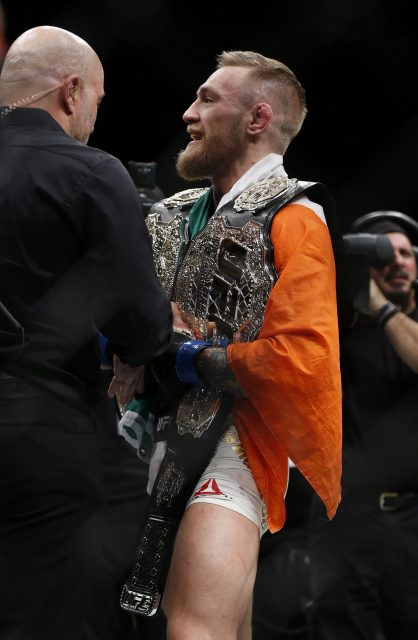 Nov 12, 2016; New York, NY, USA; Conor McGregor (blue gloves) celebrates with his two championship belts after defeating Eddie Alvarez (red gloves) in their lightweight title bout during UFC 205 at Madison Square Garden. Mandatory Credit: Adam Hunger-USA TODAY Sports