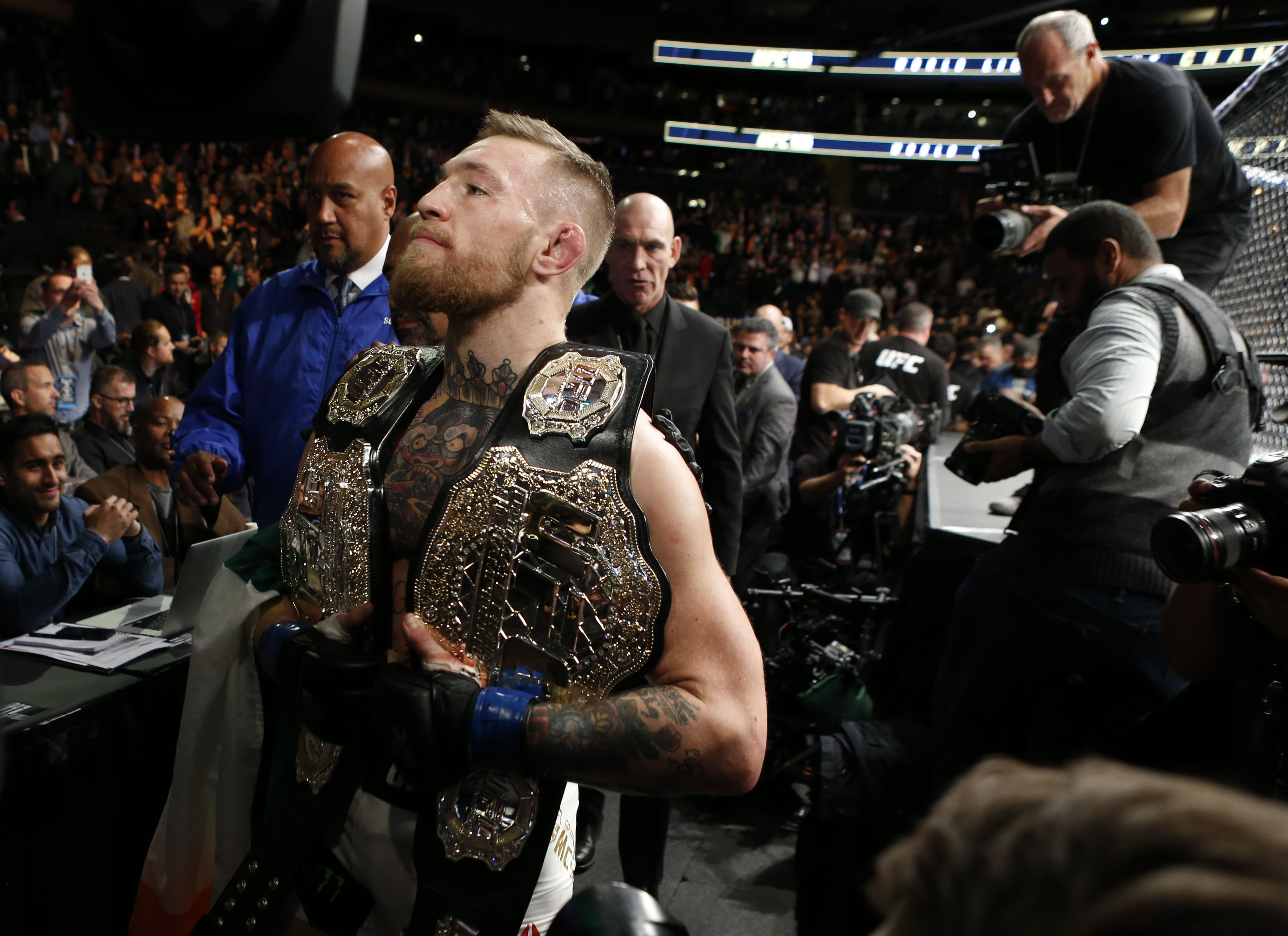 Nov 12, 2016; New York, NY, USA; Conor McGregor (blue gloves) celebrates with his two championship belts after defeating Eddie Alvarez (red gloves) in their lightweight title bout during UFC 205 at Madison Square Garden. Mandatory Credit: Adam Hunger-USA TODAY Sports