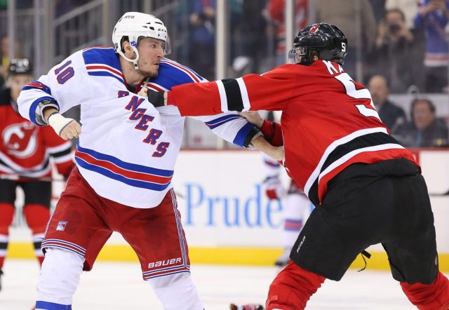 Feb 23, 2016; Newark, NJ, USA; New York Rangers center J.T. Miller (10) and New Jersey Devils center Sergey Kalinin (51) fight during the second period at Prudential Center. Miller received a match penalty for having tape too low on his hand. Mandatory Credit: Ed Mulholland-USA TODAY Sports