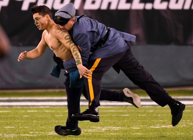 Dec 5, 2016; East Rutherford, NJ, USA;   A New Jersey State Trooper tackles a fan who ran on to the field during a game between the Indianapolis Colts and New York Jets at MetLife Stadium. Mandatory Credit: Robert Deutsch-USA TODAY Sports