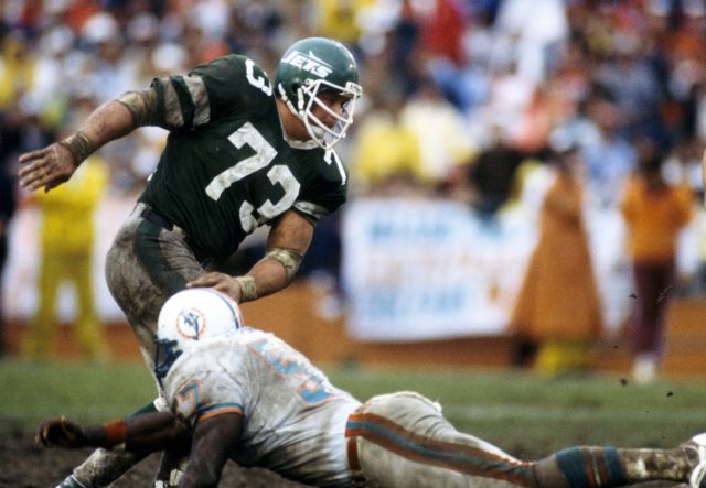 Boomer Esiason (L) and Joe Klecko talk on the field before the New