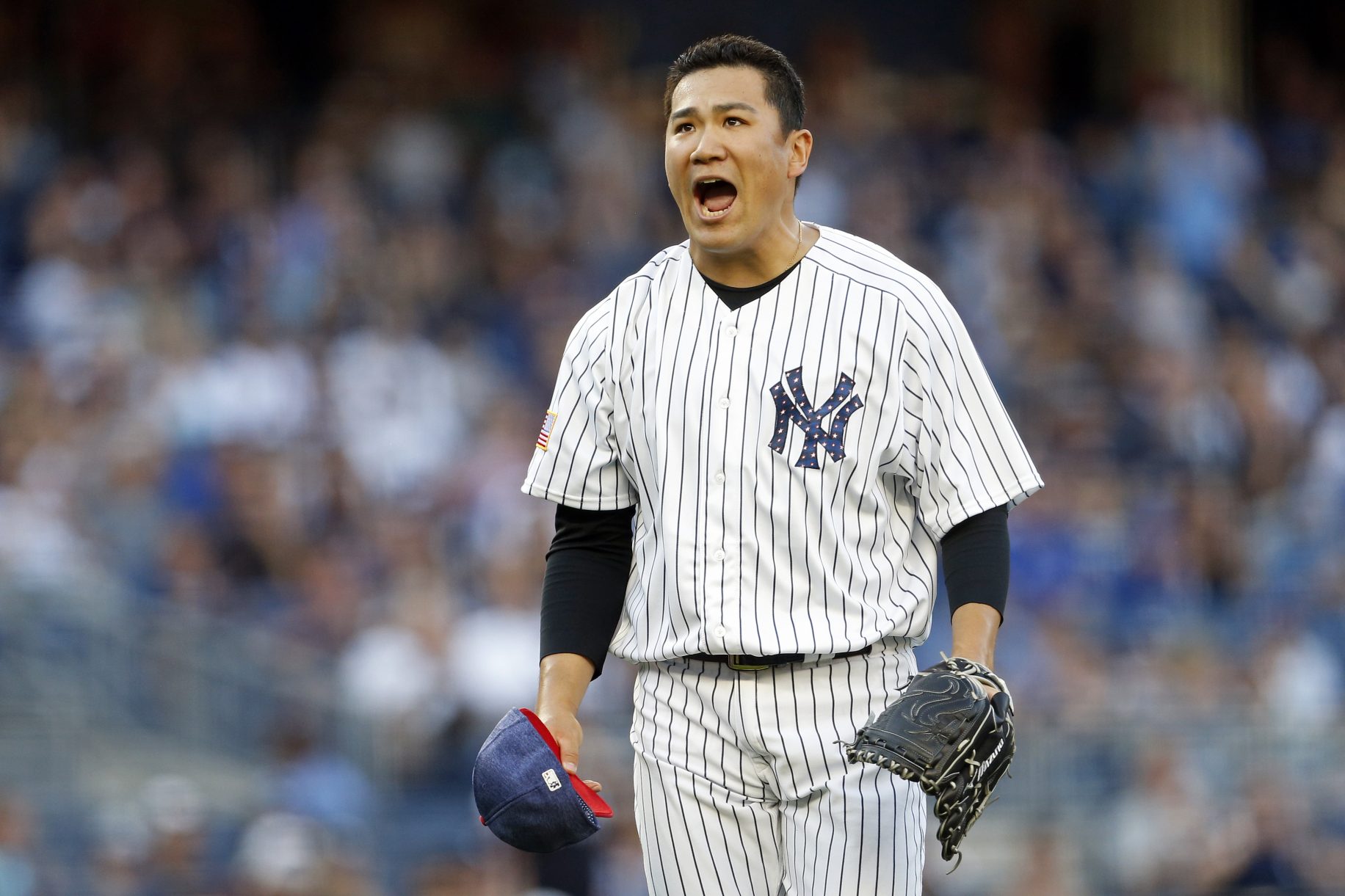 New York Yankees Masahiro Tanaka speaks to the media in his new Yankee hat  and jersey at a press conference at Yankee Stadium in New York City on  February 11, 2014. The