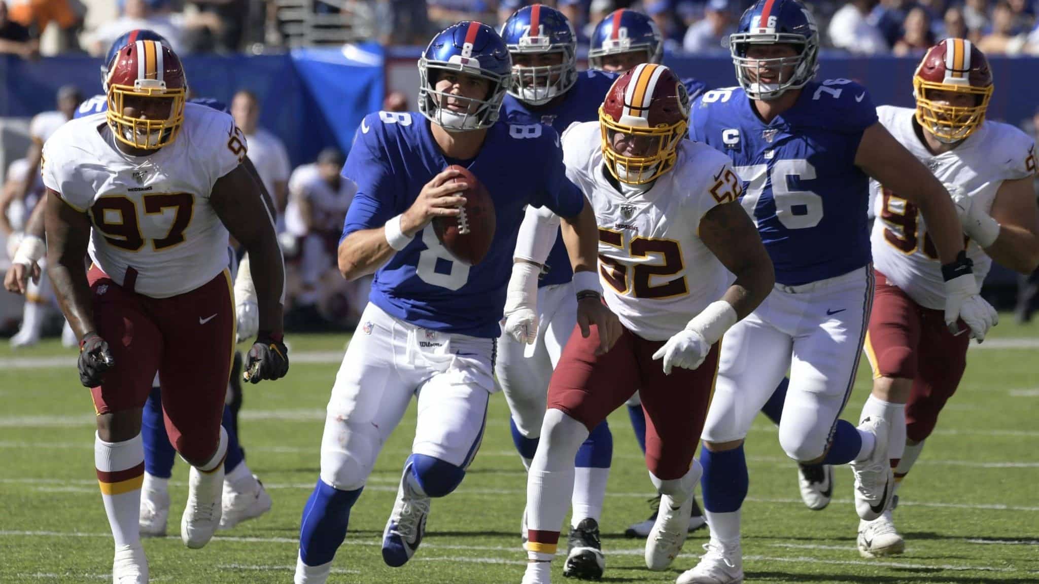 New York Giants quarterback Daniel Jones, second from left, runs the ball during the first half of an NFL football game against the Washington Redskins, Sunday, Sept. 29, 2019, in East Rutherford, N.J.