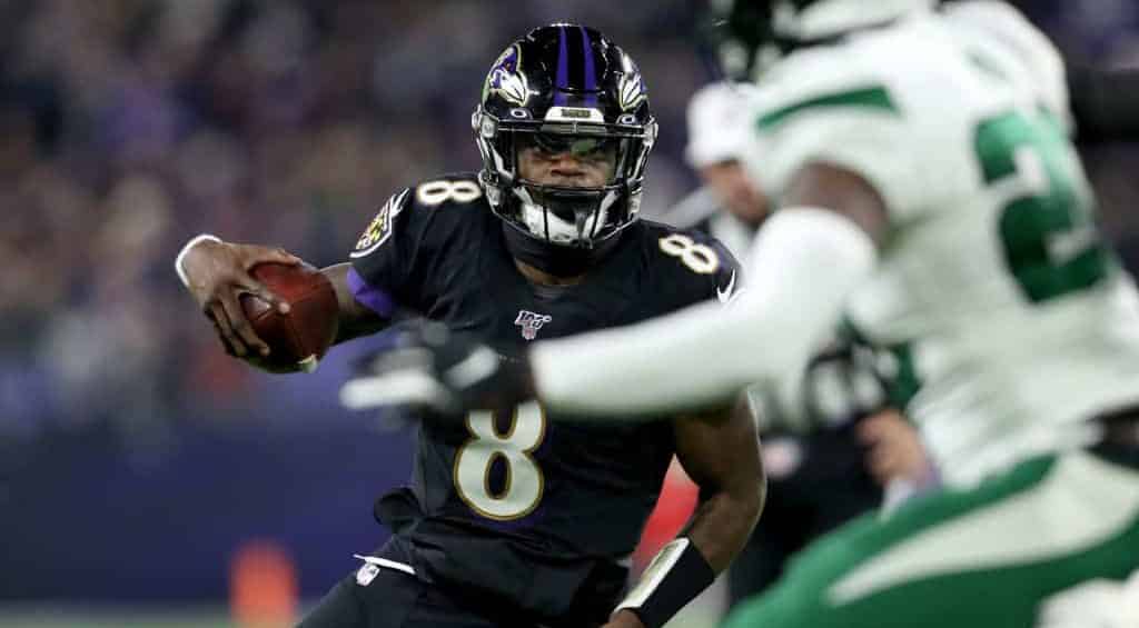 BALTIMORE, MARYLAND - DECEMBER 12: Quarterback Lamar Jackson #8 of the Baltimore Ravens breaks NFL single season record for rushing yards by a quarterback, formerly held by Michael Vick in the first quarter of the game against the New York Jets at M&T Bank Stadium on December 12, 2019 in Baltimore, Maryland.