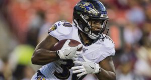 LANDOVER, MD - AUGUST 29: Kenneth Dixon #30 of the Baltimore Ravens carries the ball during the first half of a preseason game against the Washington Redskins at FedExField on August 29, 2019 in Landover, Maryland.