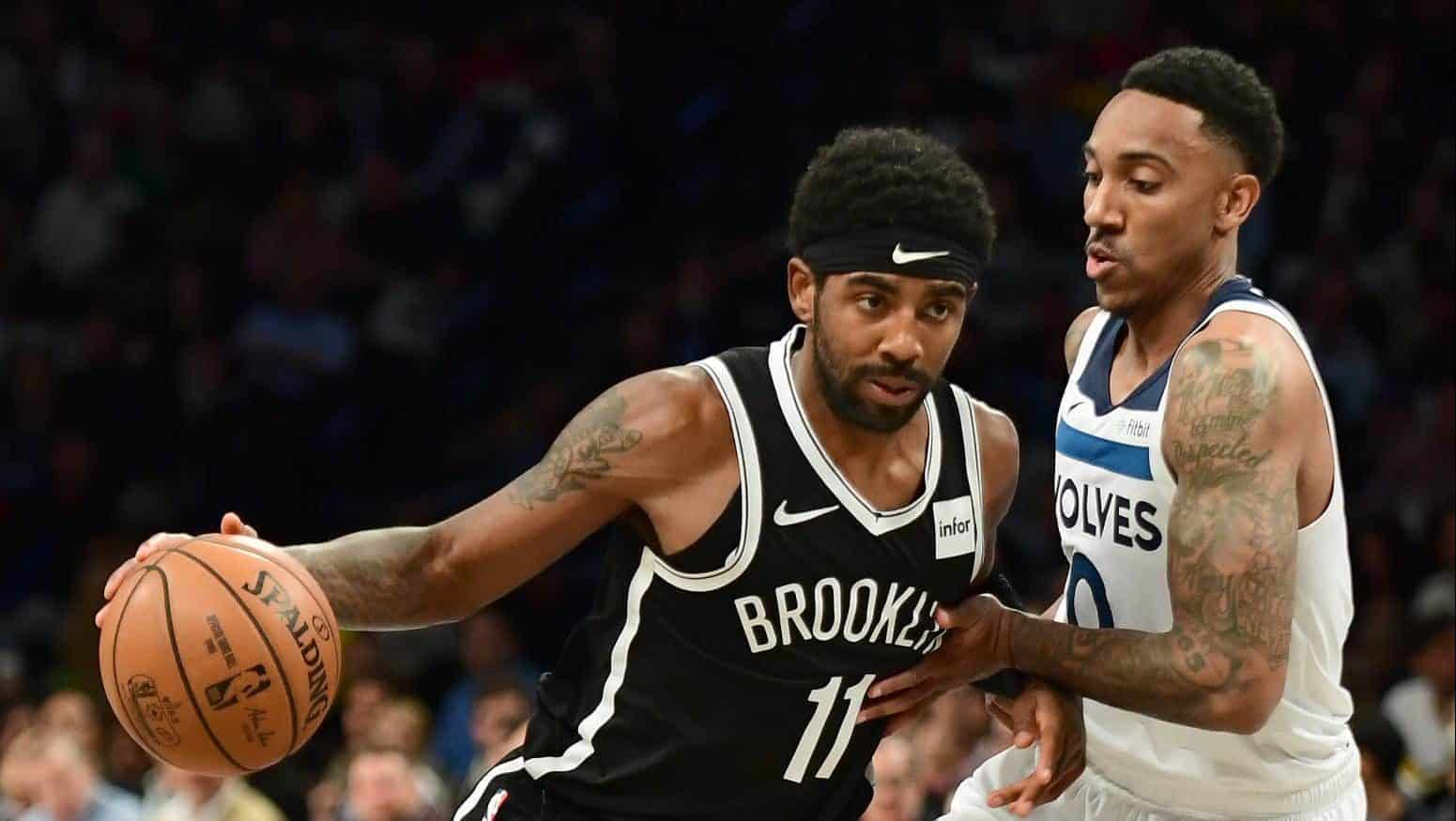 NEW YORK, NEW YORK - OCTOBER 23: Jeff Teague #0 of the Minnesota Timberwolves guards Kyrie Irving #11 of the Brooklyn Nets as he dribbles the ball during the first half of their game at Barclays Center on October 23, 2019 in the Brooklyn borough of New York City. NOTE TO USER: User expressly acknowledges and agrees that, by downloading and or using this photograph, User is consenting to the terms and conditions of the Getty Images License Agreement.