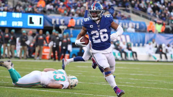 EAST RUTHERFORD, NEW JERSEY - DECEMBER 15: Saquon Barkley #26 of the New York Giants scores a touchdown in the third quarter against the Miami Dolphins during their game at MetLife Stadium on December 15, 2019 in East Rutherford, New Jersey.