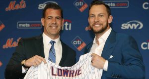 FILE - In this Jan. 16, 2019, file photo, New York Mets general manager Brodie Van Wagenen, left, poses for a photograph with new infielder Jed Lowrie during a baseball news conference in New York.