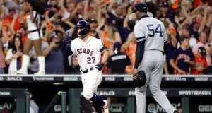 HOUSTON, TEXAS - OCTOBER 19: Jose Altuve #27 of the Houston Astros comes home to score following his ninth inning walk-off two-run home run as Aroldis Chapman #54 of the New York Yankees walks off the field in game six of the American League Championship Series at Minute Maid Park on October 19, 2019 in Houston, Texas. The Astros defeated the Yankees 6-4.