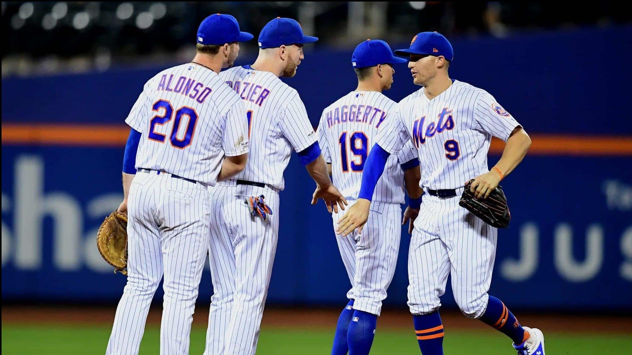 NEW YORK, NEW YORK - SEPTEMBER 25: Brandon Nimmo #9 high fives Sam Haggerty #19, Todd Frazier #21, and Pete Alonso #20 of the New York Mets after their 10-3 win over the Miami Marlins at Citi Field on September 25, 2019 in the Flushing neighborhood of the Queens borough in New York City.