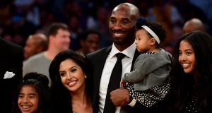 LOS ANGELES, CA - DECEMBER 18: Kobe Bryant poses with his family at halftime after both his #8 and #24 Los Angeles Lakers jerseys are retired at Staples Center on December 18, 2017 in Los Angeles, California.