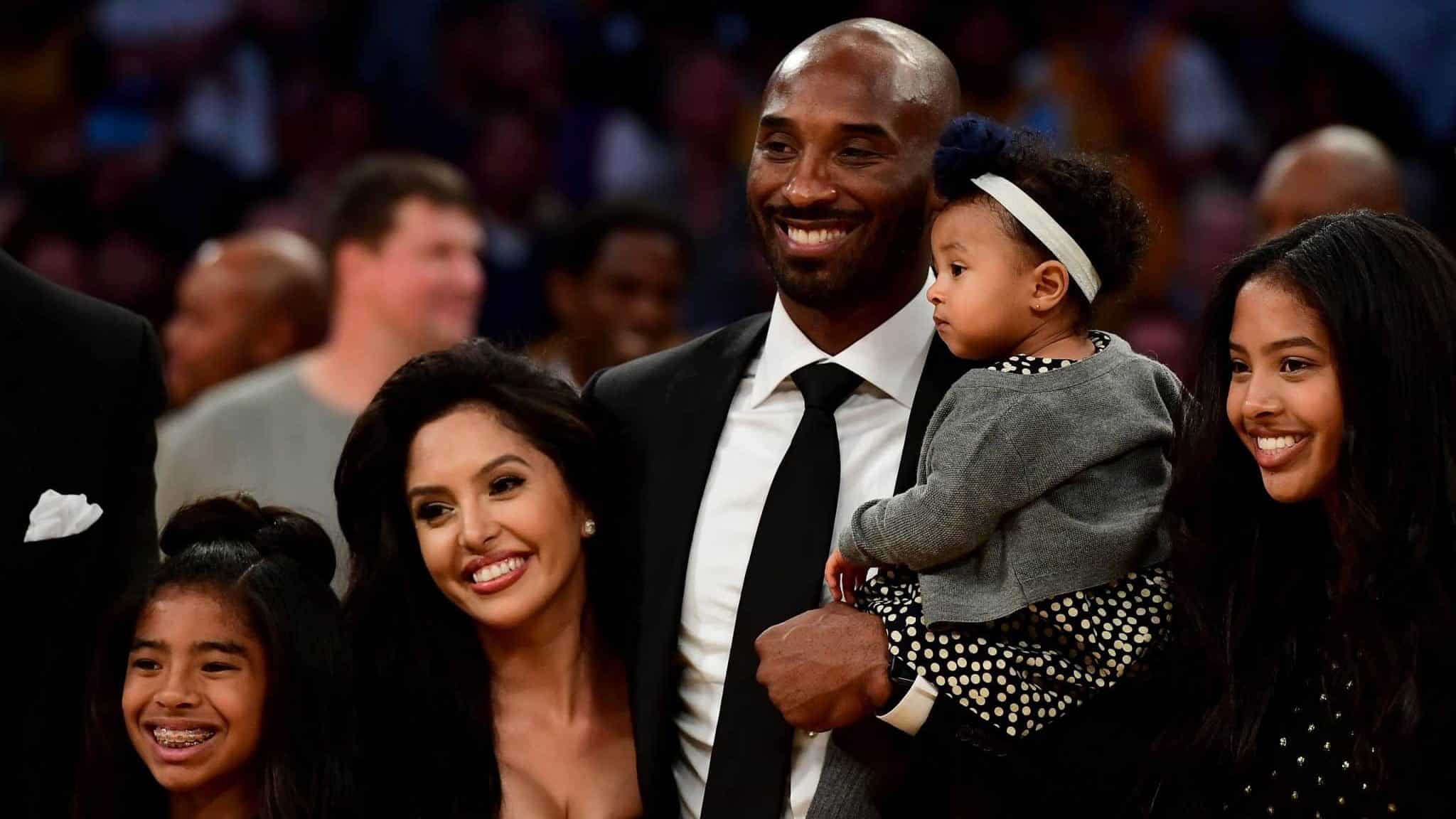 LOS ANGELES, CA - DECEMBER 18: Kobe Bryant poses with his family at halftime after both his #8 and #24 Los Angeles Lakers jerseys are retired at Staples Center on December 18, 2017 in Los Angeles, California.