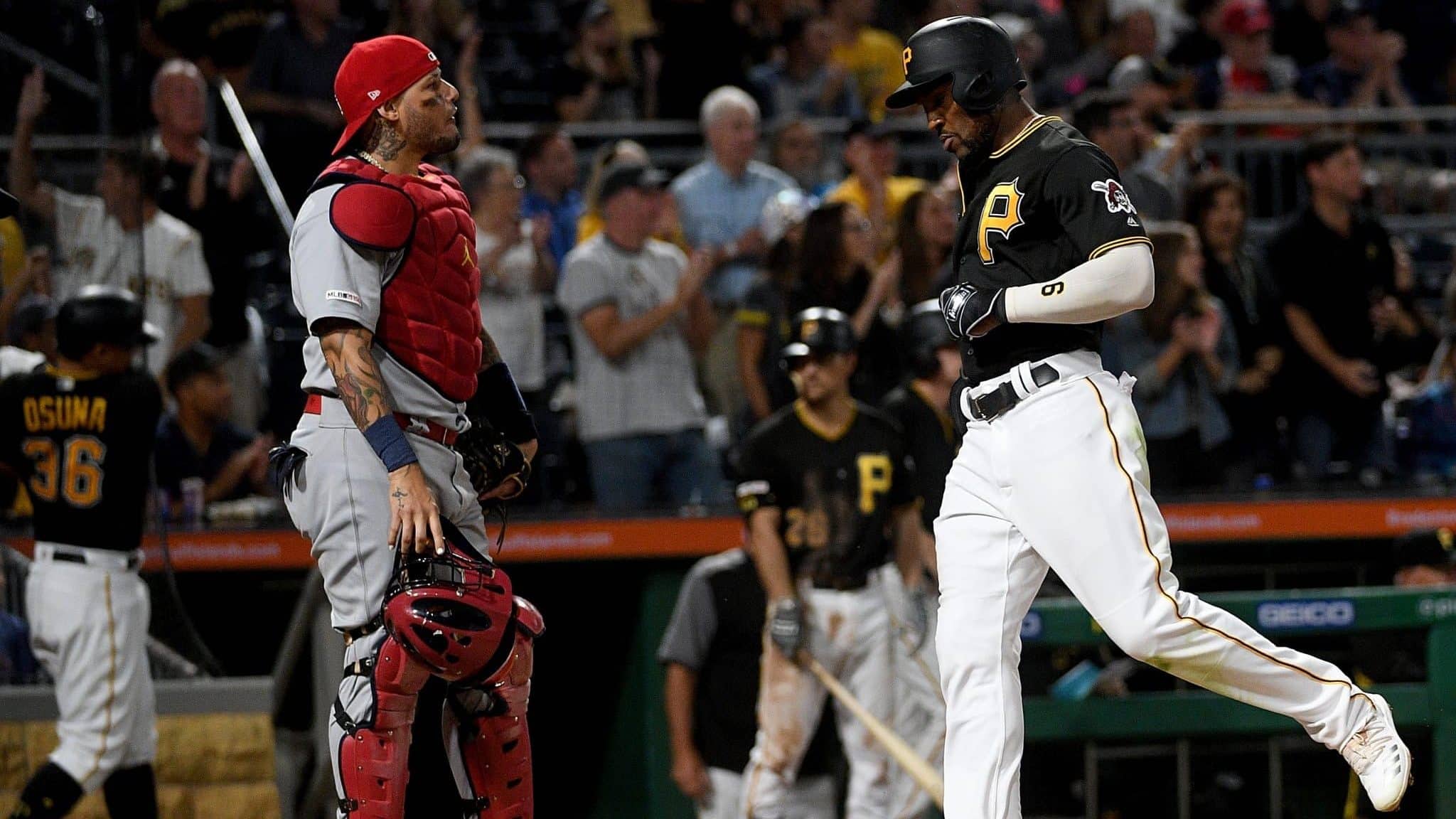 PITTSBURGH, PA - SEPTEMBER 06: Starling Marte #6 of the Pittsburgh Pirates comes around to score in front of Yadier Molina #4 of the St. Louis Cardinals in the seventh inning during the game at PNC Park on September 6, 2019 in Pittsburgh, Pennsylvania.