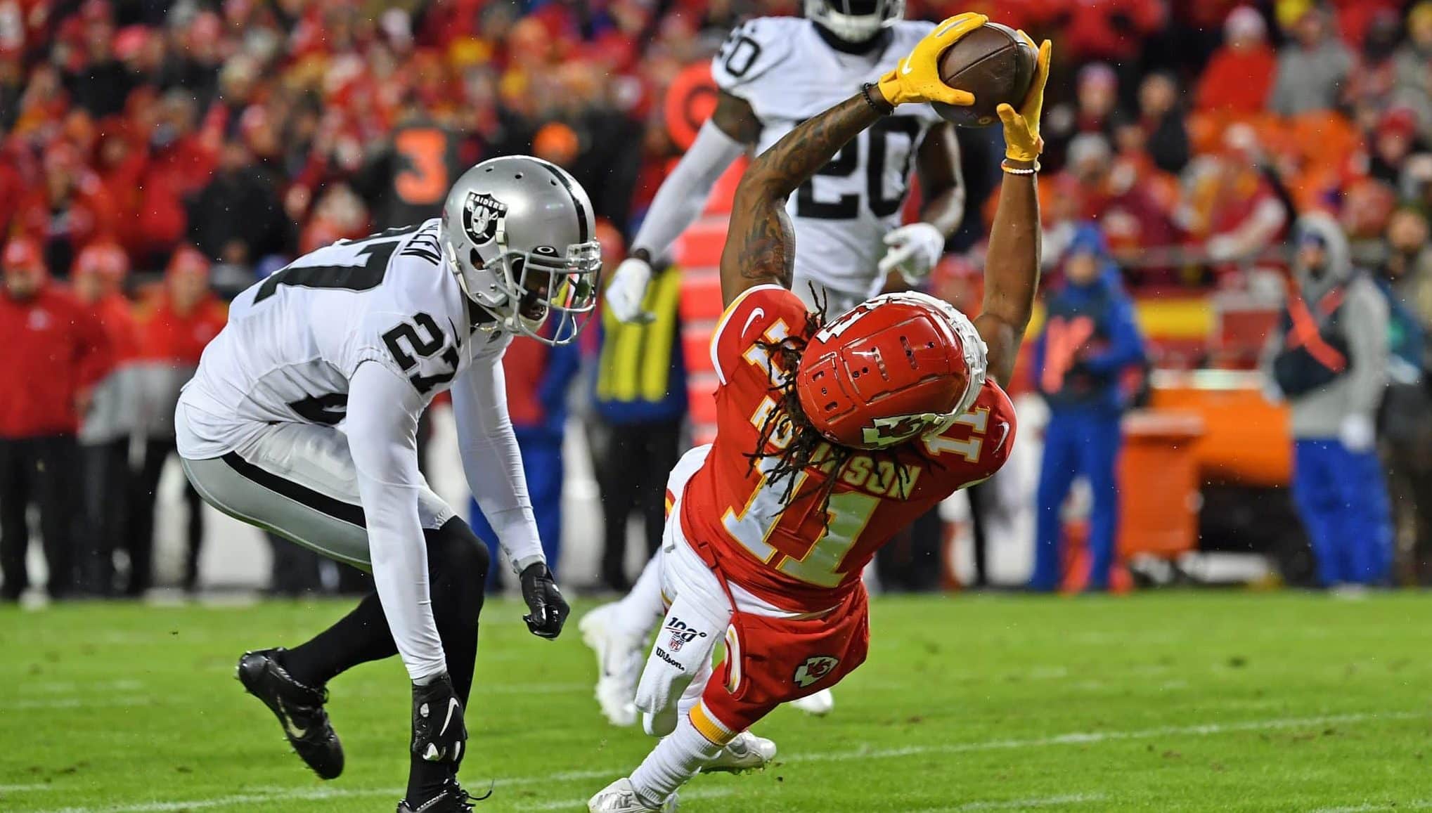 KANSAS CITY, MO - DECEMBER 01: Wide receiver Demarcus Robinson #11 of the Kansas City Chiefs stretches for extra yardage against cornerback Trayvon Mullen #27 of the Oakland Raiders during the second half at Arrowhead Stadium on December 1, 2019 in Kansas City, Missouri.