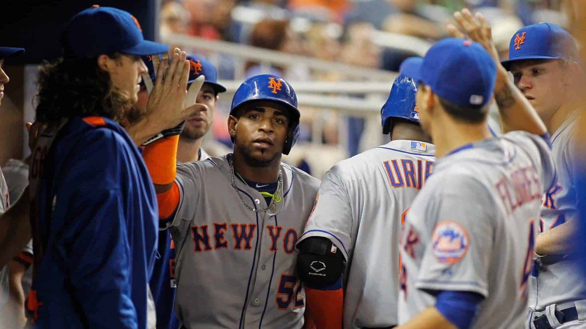 MIAMI, FL - SEPTEMBER 04: Yoenis Cespedes #52 of the New York Mets is congratulated by teammates including pitcher Jacob deGrom (L) after he scored in the sixth inning of play against the Miami Marlins at Marlins Park on September 4, 2015 in Miami, Florida.