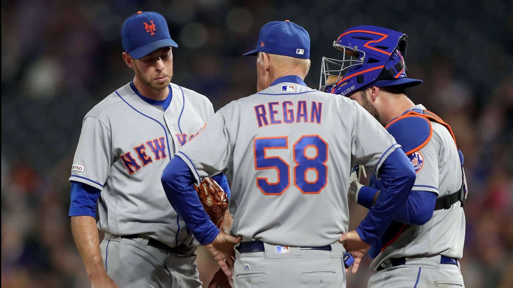 DENVER, COLORADO - SEPTEMBER 16: Starting pitcher Steven Matz #32 , pitching coach Phil Regan #58 and catcher Tomas Nido #3 of the New York Mets confer in the fourth inning against the Colorado Rockies at Coors Field on September 16, 2019 in Denver, Colorado.
