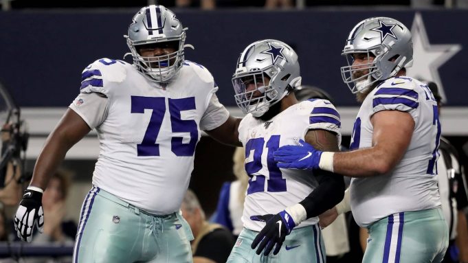 ARLINGTON, TEXAS - DECEMBER 29: Cameron Fleming #75, Ezekiel Elliott #21, and Travis Frederick #72 of the Dallas Cowboys celebrate after scoring a touchdown in the second quarter against the Washington Redskins in the game at AT&T Stadium on December 29, 2019 in Arlington, Texas.