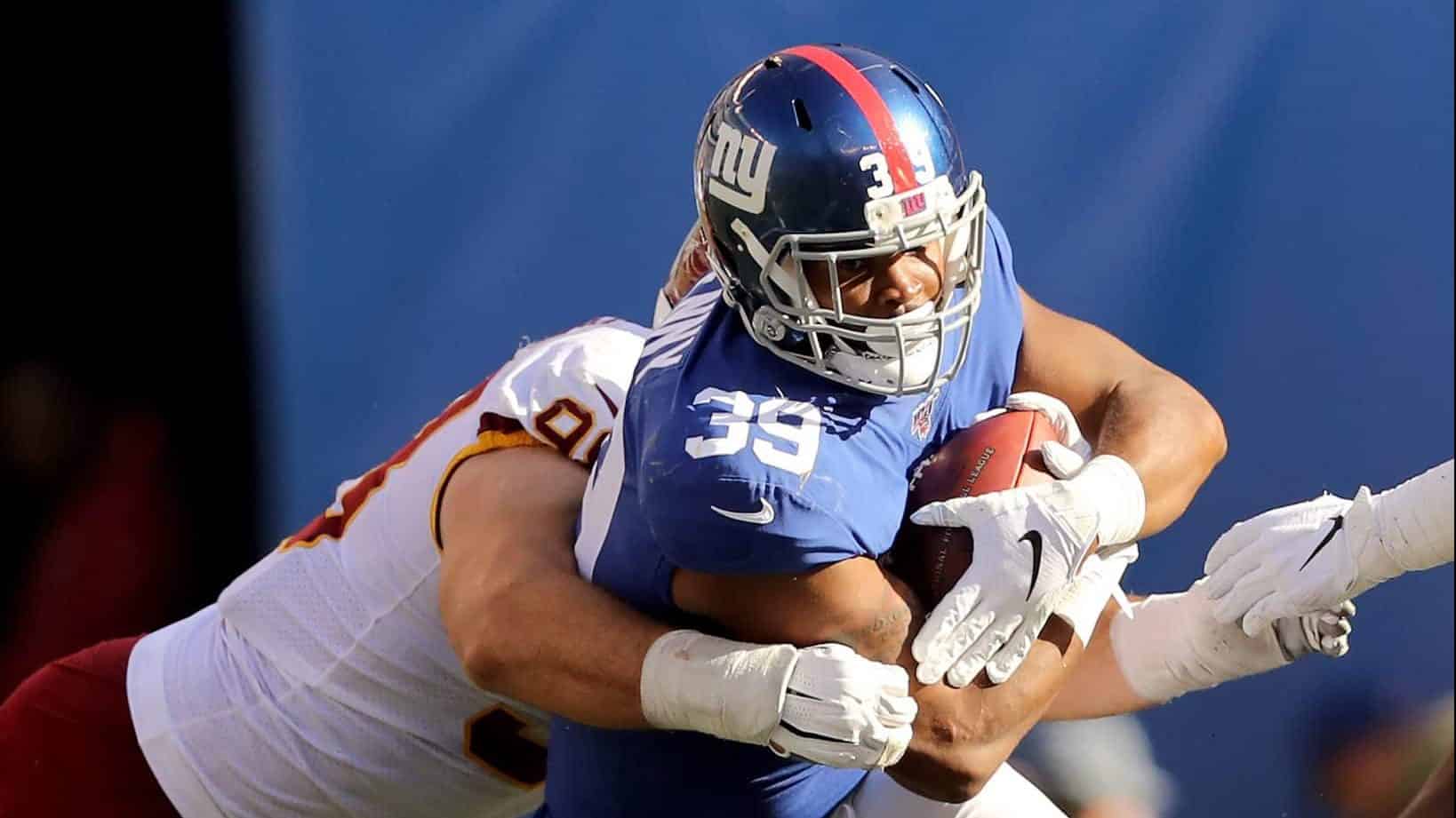 EAST RUTHERFORD, NEW JERSEY - SEPTEMBER 29: Elijhaa Penny #39 of the New York Giants carries the ball as Matthew Ioannidis #98 of the Washington Redskins defends in the fourth quarter at MetLife Stadium on September 29, 2019 in East Rutherford, New Jersey.