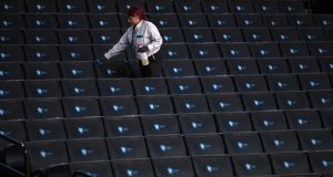 NEW YORK, NEW YORK - MARCH 12: A worker disinfects seats prior to the start of the second round of the 2020 Atlantic 10 men's basketball tournament at Barclays Center on March 12, 2020 in the Brooklyn borough of New York City. The tournament was canceled amid growing concerns of the spread of Coronavirus (COVID-19).