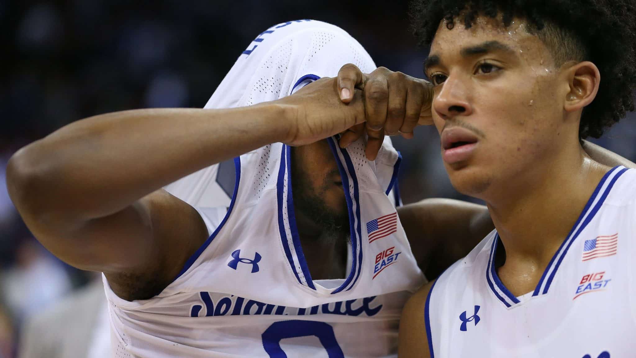 NEWARK, NJ - MARCH 04: Quincy McKnight #0 of the Seton Hall Pirates pulls his jersey over his head as he walks off the court with teammate Jared Rhoden #14 after losing to the Villanova Wildcats 79-77 in a college basketball game at Prudential Center on March 4, 2020 in Newark, New Jersey.
