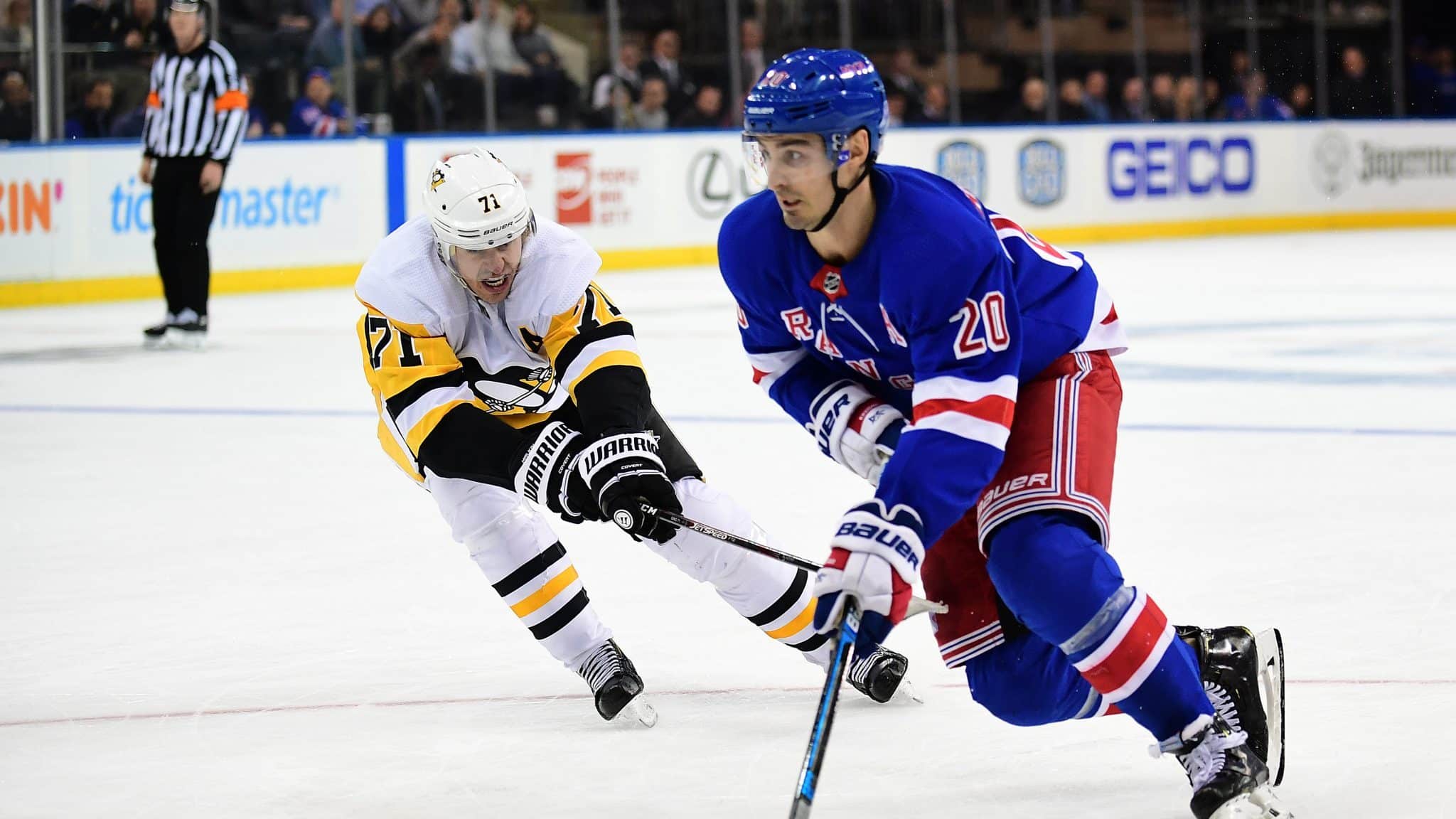 NEW YORK, NEW YORK - NOVEMBER 12: Chris Kreider #20 of the New York Rangers controls the puck with pressure from Evgeni Malkin #71 of the Pittsburgh Penguins during their game at Madison Square Garden on November 12, 2019 in New York City.