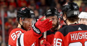 NEWARK, NEW JERSEY - FEBRUARY 08: Jesper Bratt #63 of the New Jersey Devils talks with teammates Kyle Palmieri #21 and Jack Hughes #86 of the New Jersey Devils in the second period against the Los Angeles Kings at Prudential Center on February 08, 2020 in Newark, New Jersey.