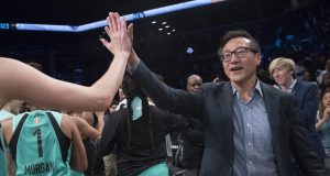 The New York Liberty's new owner, Joe Tsai, right, high-fives the Liberty players as they arrive at the bench at the end of a WNBA exhibition basketball game against China, Thursday, May 9, 2019, in New York. Tsai saw the team's exhibition game against the Chinese national team as a chance to grow relations between the two countries.