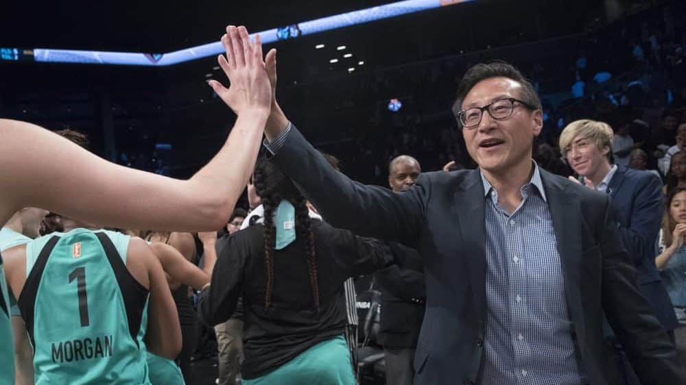 The New York Liberty's new owner, Joe Tsai, right, high-fives the Liberty players as they arrive at the bench at the end of a WNBA exhibition basketball game against China, Thursday, May 9, 2019, in New York. Tsai saw the team's exhibition game against the Chinese national team as a chance to grow relations between the two countries.