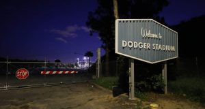 LOS ANGELES, CALIFORNIA - MARCH 26: A sign for Dodger Stadium stands next to a locked gate on what was supposed to be Major League Baseball's opening day, now postponed due to the coronavirus, on March 26, 2020 in Los Angeles, California. The Los Angeles Dodgers were slated to play against the San Francisco Giants at the stadium today. Major League Baseball Commissioner Rob Manfred recently said the league is "probably not gonna be able to" play a full 162 game regular season due to the spread of COVID-19.