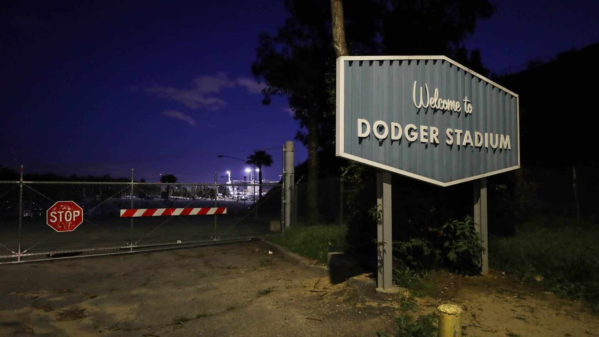LOS ANGELES, CALIFORNIA - MARCH 26: A sign for Dodger Stadium stands next to a locked gate on what was supposed to be Major League Baseball's opening day, now postponed due to the coronavirus, on March 26, 2020 in Los Angeles, California. The Los Angeles Dodgers were slated to play against the San Francisco Giants at the stadium today. Major League Baseball Commissioner Rob Manfred recently said the league is 