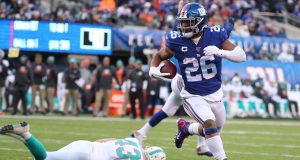 EAST RUTHERFORD, NEW JERSEY - DECEMBER 15: Saquon Barkley #26 of the New York Giants scores a touchdown in the third quarter against the Miami Dolphins during their game at MetLife Stadium on December 15, 2019 in East Rutherford, New Jersey.