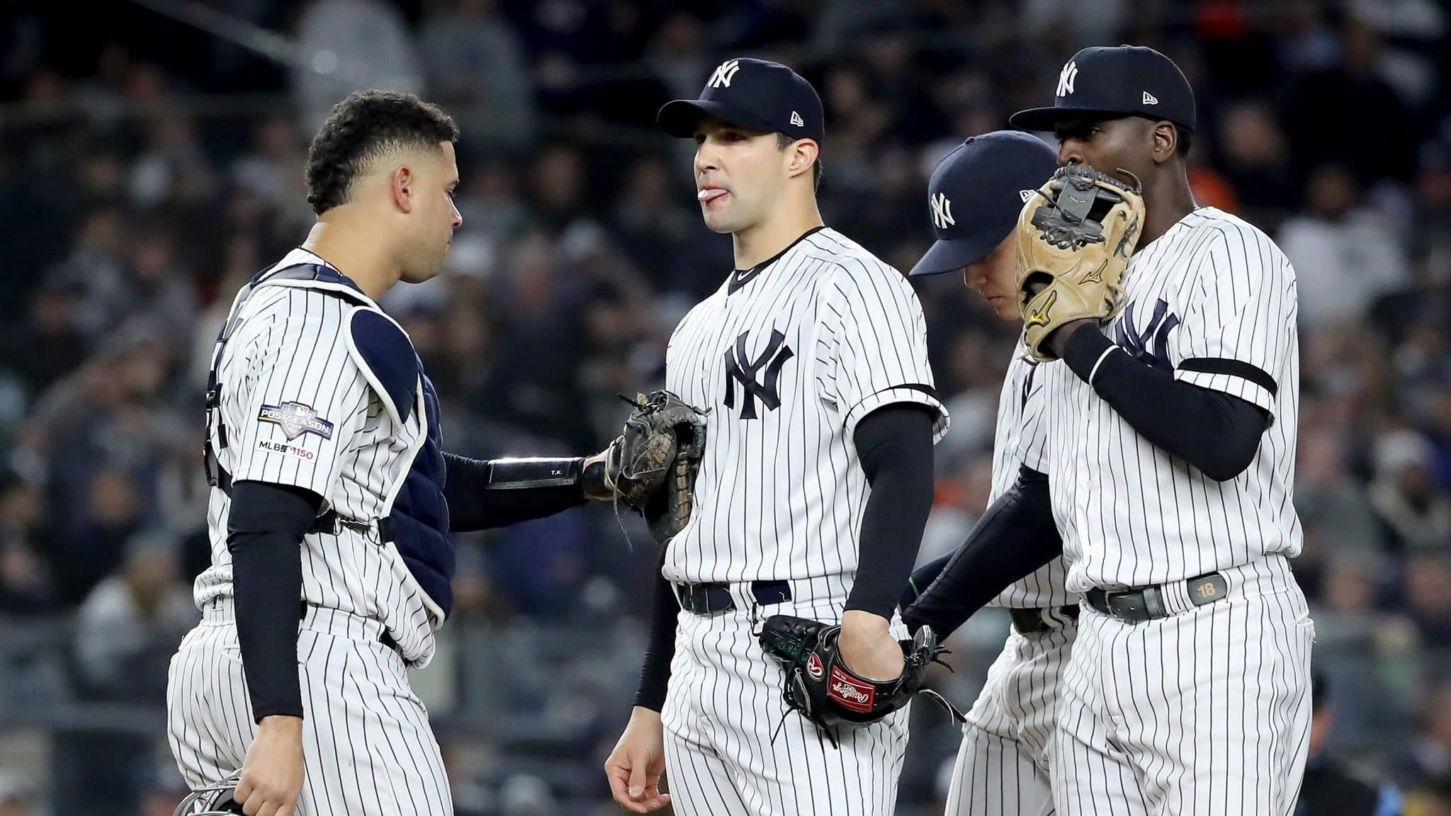 NEW YORK, NEW YORK - OCTOBER 18: Tommy Kahnle #48 of the New York Yankees talks with Gary Sanchez #24 and Didi Gregorius #18 against the Houston Astros during the seventh inning in game five of the American League Championship Series at Yankee Stadium on October 18, 2019 in New York City.