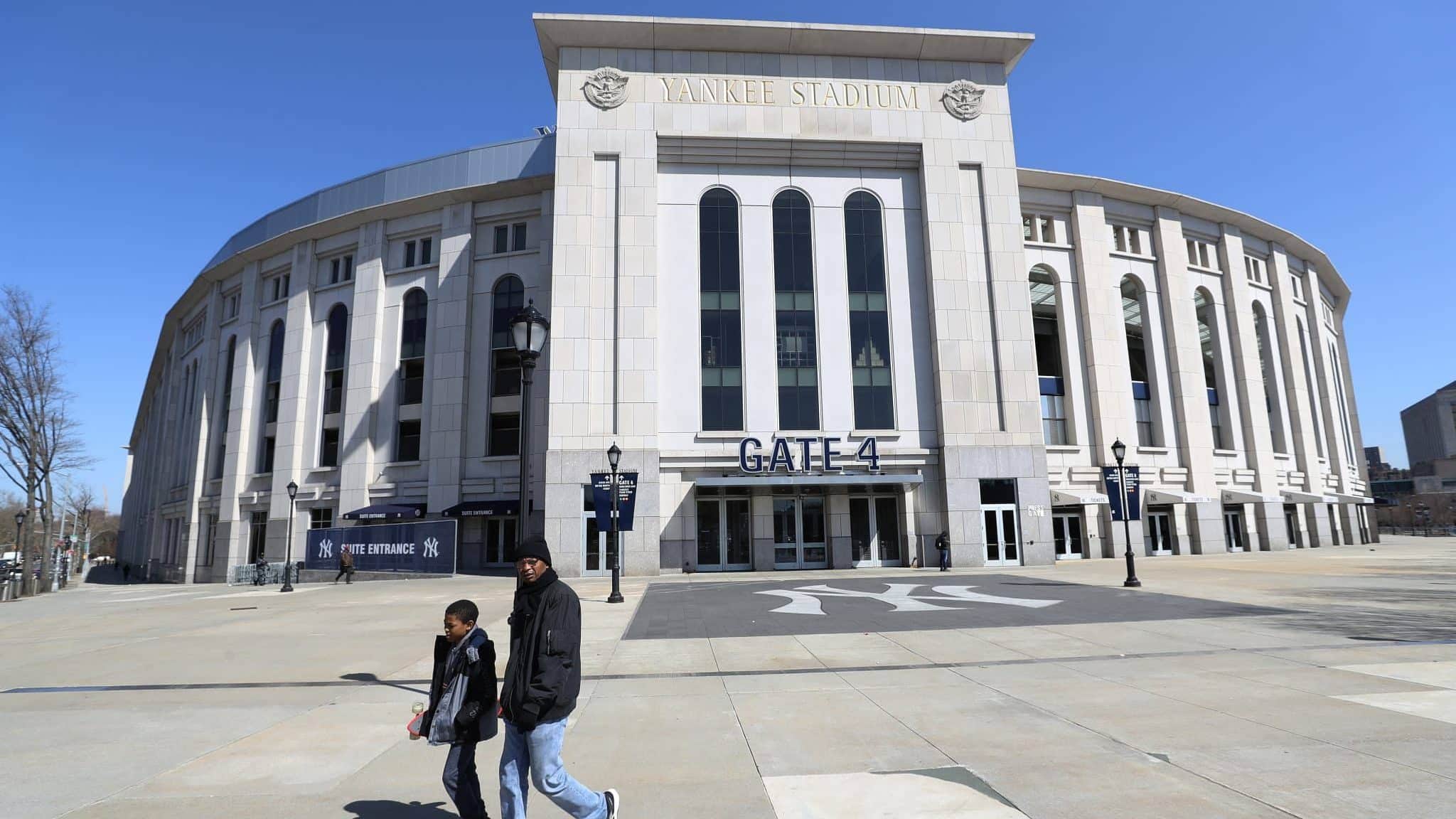 BRONX, NEW YORK - MARCH 26: A father and son walk past a closed Yankee Stadium on the scheduled date for Opening Day March 26, 2020 in the Bronx, New York. Major League Baseball has postponed the start of its season due to the coronavirus (COVID-19) outbreak and MLB commissioner Rob Manfred recently said the league is 