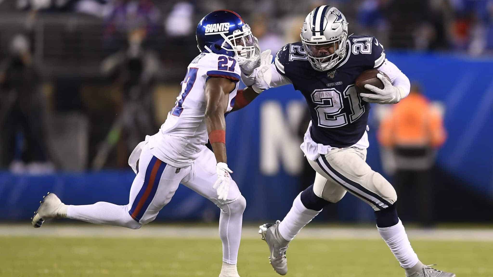 EAST RUTHERFORD, NEW JERSEY - NOVEMBER 04: Ezekiel Elliott #21 of the Dallas Cowboys carries the ball as Deandre Baker #27 of the New York Giants defends during the fourth quarter of the game at MetLife Stadium on November 04, 2019 in East Rutherford, New Jersey.