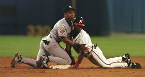 23 Oct 1996: Marquis Grissom of the Atlanta Braves dives safely into base and Mariano Duncan of the New York Yankees after hitting a 2 RBI double in the second inning of game four of the World Series at Fulton County Stadium in Atlanta, Georgia.