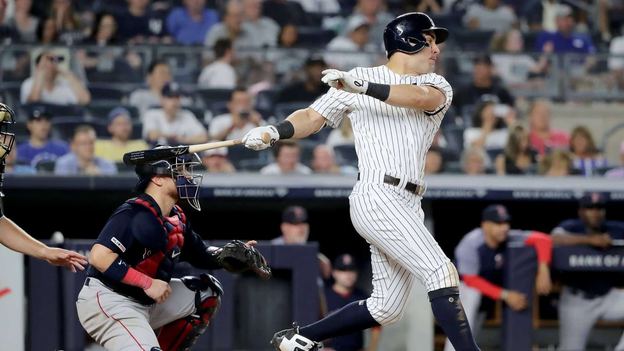 NEW YORK, NEW YORK - AUGUST 03: Mike Tauchman #39 of the New York Yankees hits a 2 RBI single in the seventh inning as Christian Vazquez #7 of the Boston Red Sox defends during game two of a double header at Yankee Stadium on August 03, 2019 in New York City.