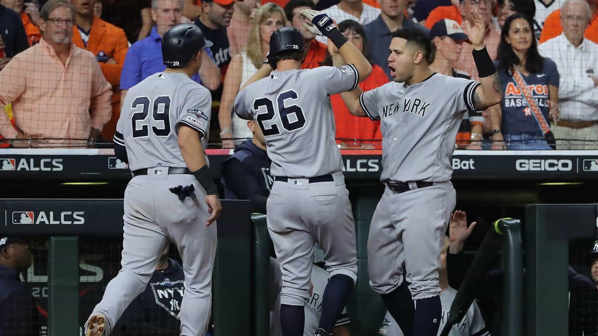 HOUSTON, TEXAS - OCTOBER 19: DJ LeMahieu #26 of the New York Yankees is congratulated by his teammates Gio Urshela #29 and Gary Sanchez #24 after his game-tying two-run home run against the Houston Astros during the ninth inning in game six of the American League Championship Series at Minute Maid Park on October 19, 2019 in Houston, Texas.