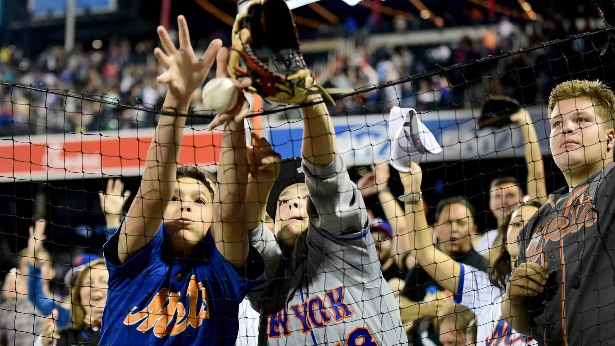 NEW YORK, NEW YORK - SEPTEMBER 27: Fans reach for a ball thrown by Robinson Cano #24 of the New York Mets during their game against the Atlanta Braves at Citi Field on September 27, 2019 in the Flushing neighborhood of the Queens borough of New York City.