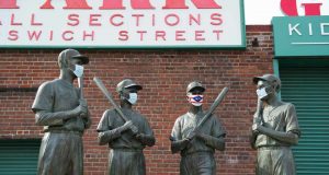 BOSTON, MA - JULY 24: A mask is placed on the Teammates Statue on Ispwich Street on Opening Day at Fenway Park on July 24, 2020 in Boston, Massachusetts. The 2020 season had been postponed since March due to the COVID-19 pandemic. MLB