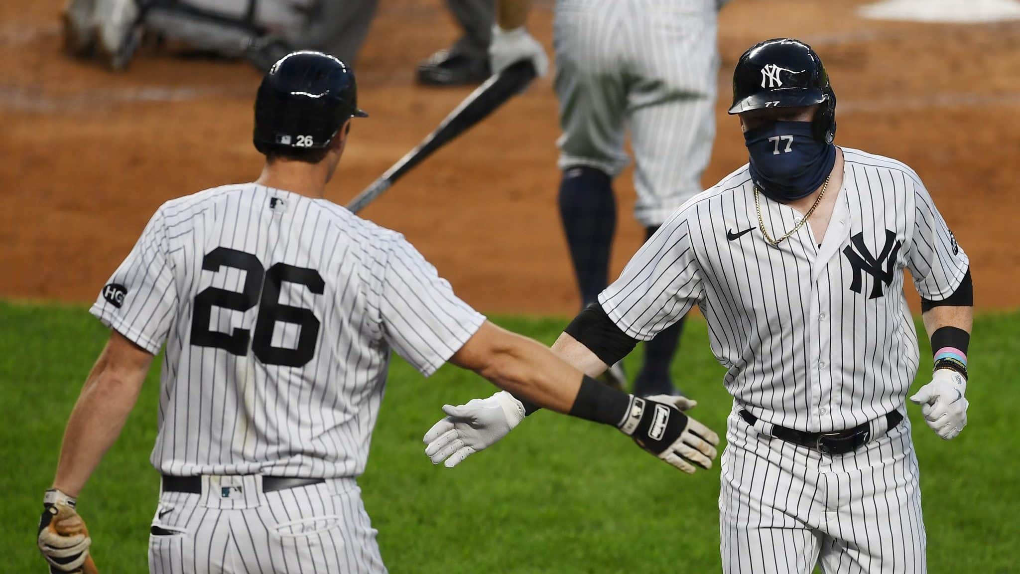 NEW YORK, NEW YORK - AUGUST 12: Clint Frazier #77 of the New York Yankees slaps gloved hands with DJ LeMahieu #26 after Frazier's home run in the second inning against the Atlanta Braves at Yankee Stadium on August 12, 2020 in the Bronx borough of New York City.